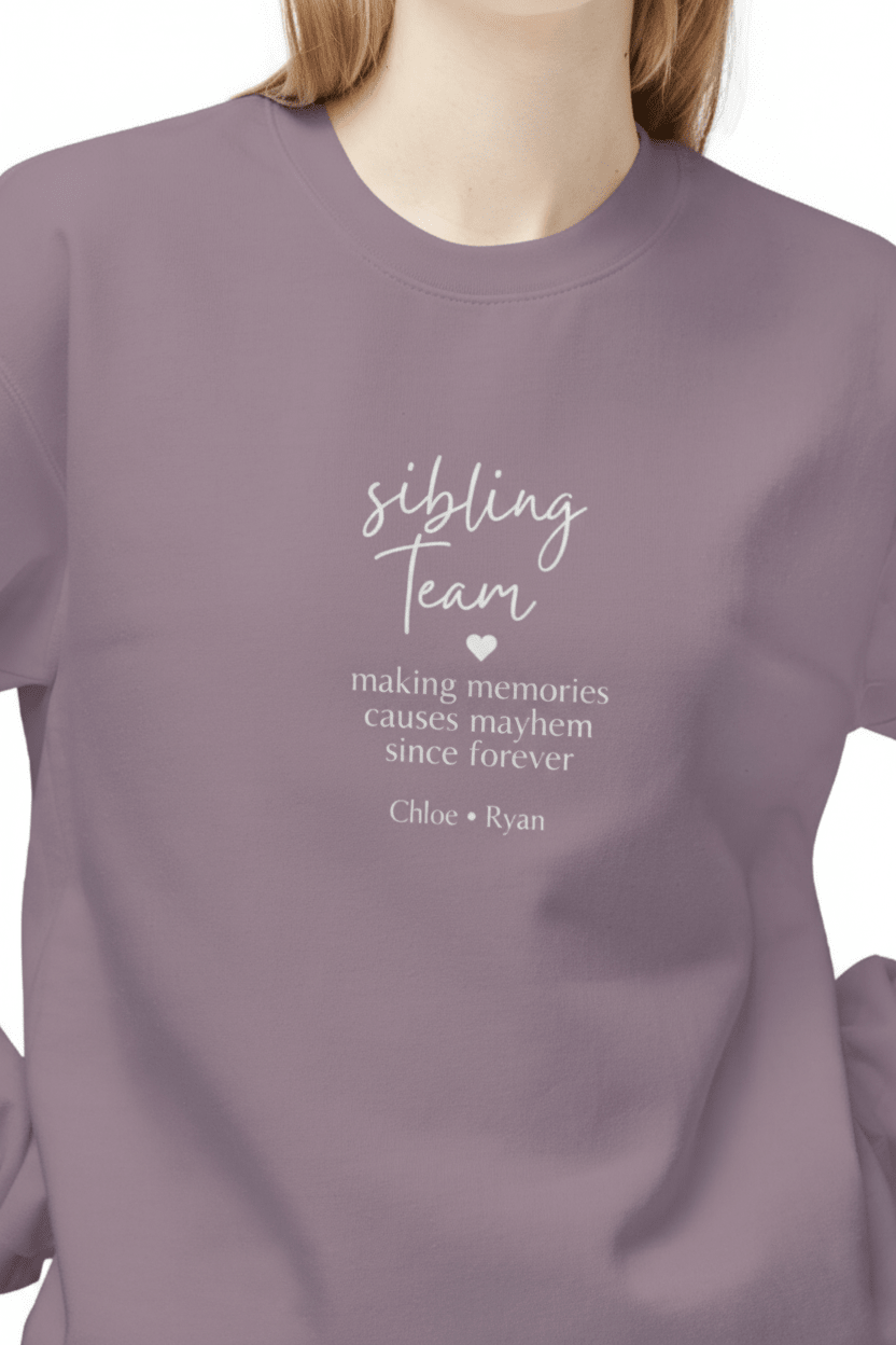 Lavender crewneck sweatshirt close-up with “sibling team” quote lettering on chest