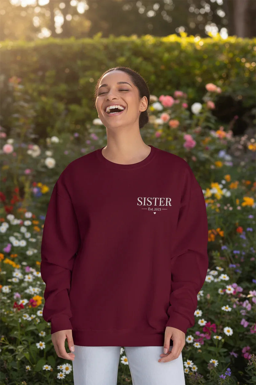 Personalised burgundy sweatshirt with front text "SISTER" and small Est date, worn