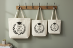 Set of three white graduation tote bags with Class of 2026 wreath and cap print