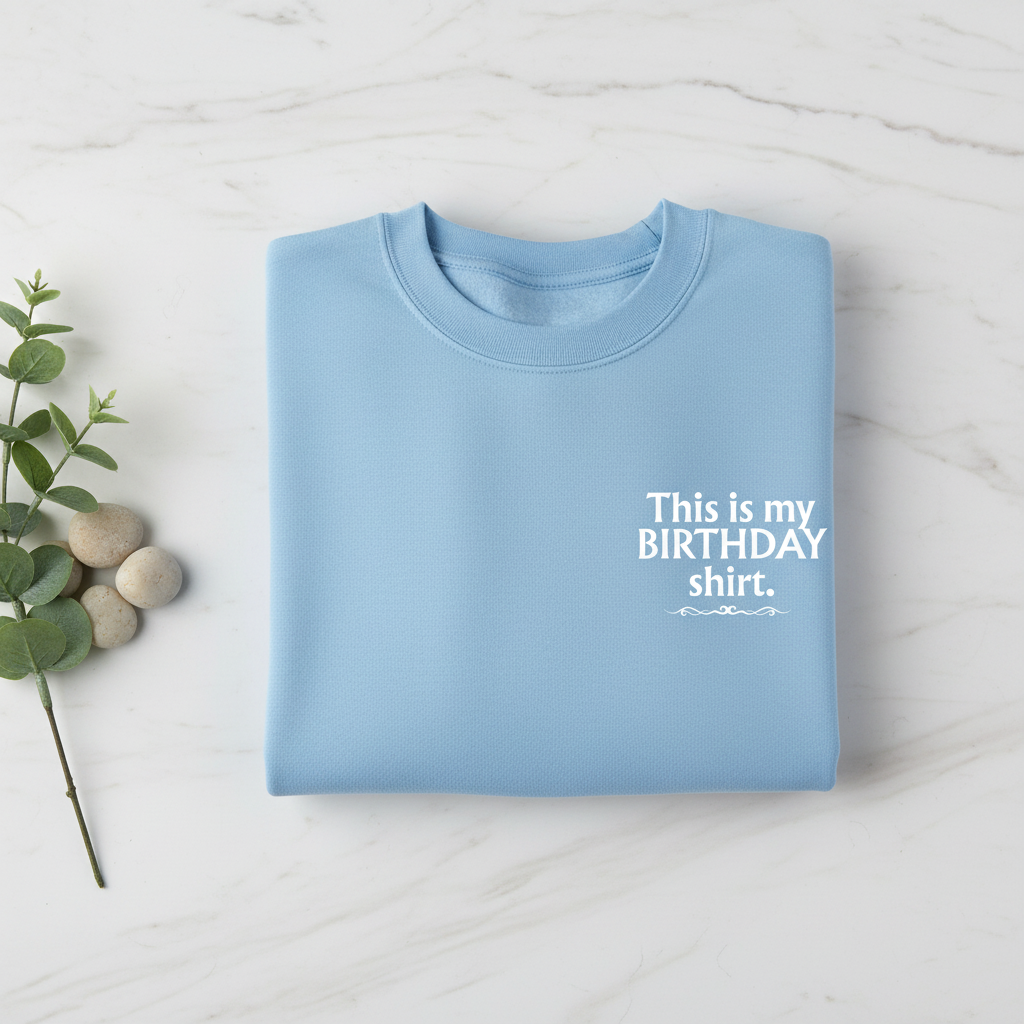Sky blue crewneck birthday shirt with “This is my BIRTHDAY shirt” print.