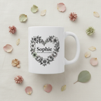 White ceramic mug with floral heart wreath and “Sophie” on front