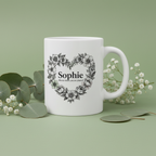 White ceramic mug with floral heart wreath and name Sophie, printed front