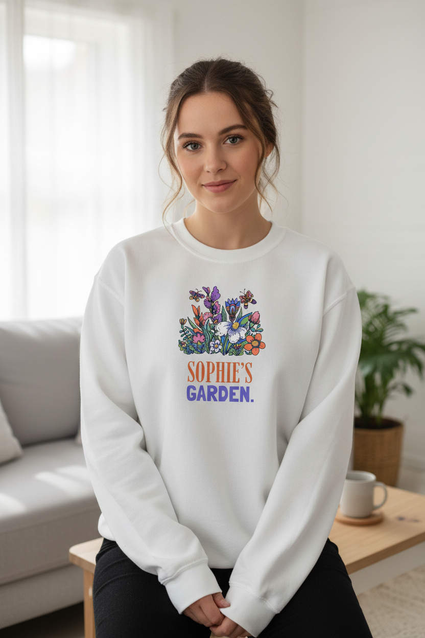 Personalized garden crewneck sweatshirt in white with floral graphic and “SOPHIE’S GARDEN” text.