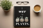 A5 spiral notebook, black cover with “I wet my plants” lettering and three succulent pots.