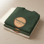 Forest green t-shirt with round wood-slice Seasoned graphic on chest, stacked with white tee