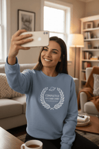 Light blue sweatshirt on model with white 'Completed Another Orbit' wreath graphic