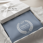 Light blue sweatshirt in gift box with white 'Completed Another Orbit' wreath logo