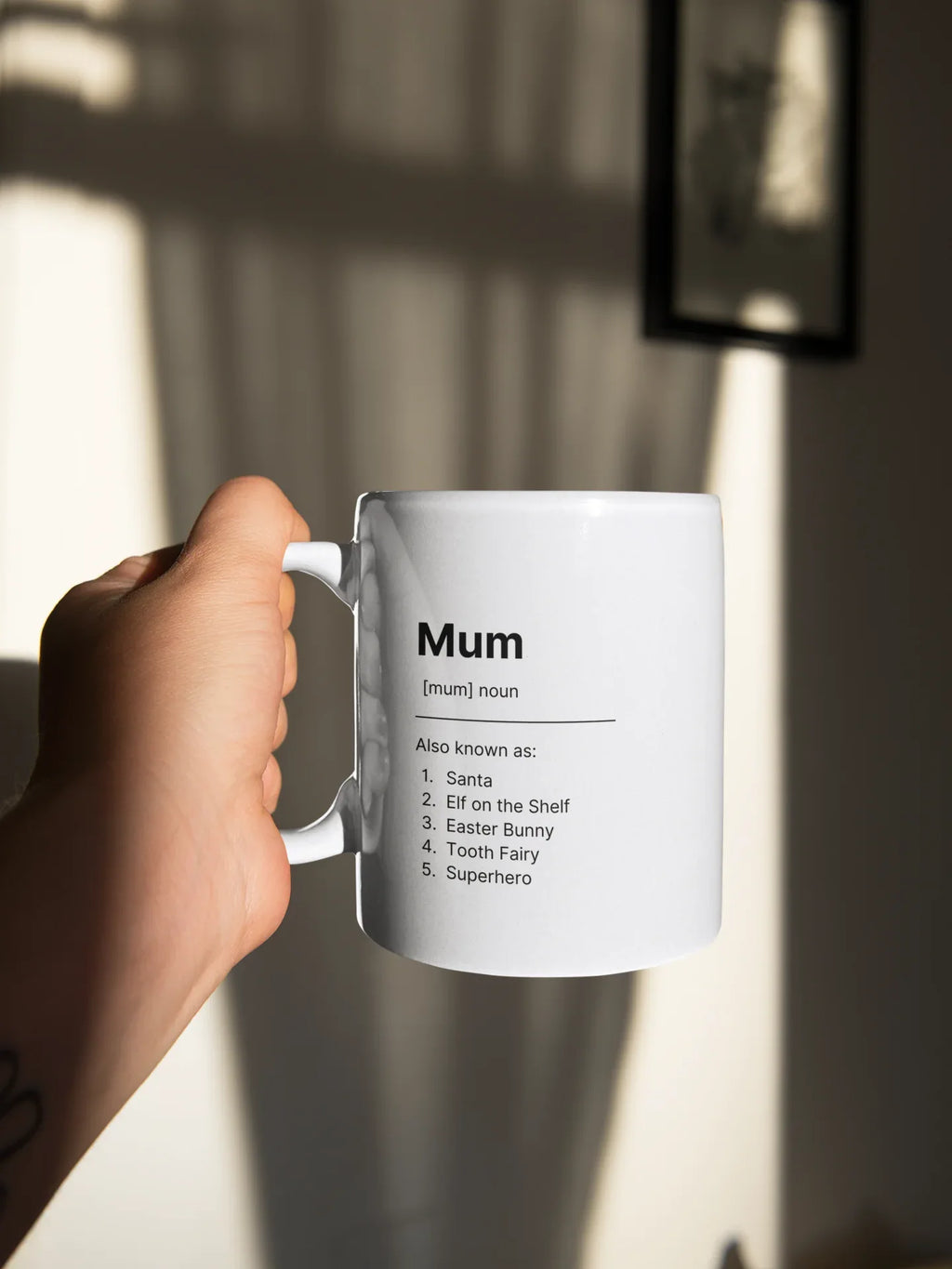 White ceramic mug held by hand; shows “Mum” and short saying list