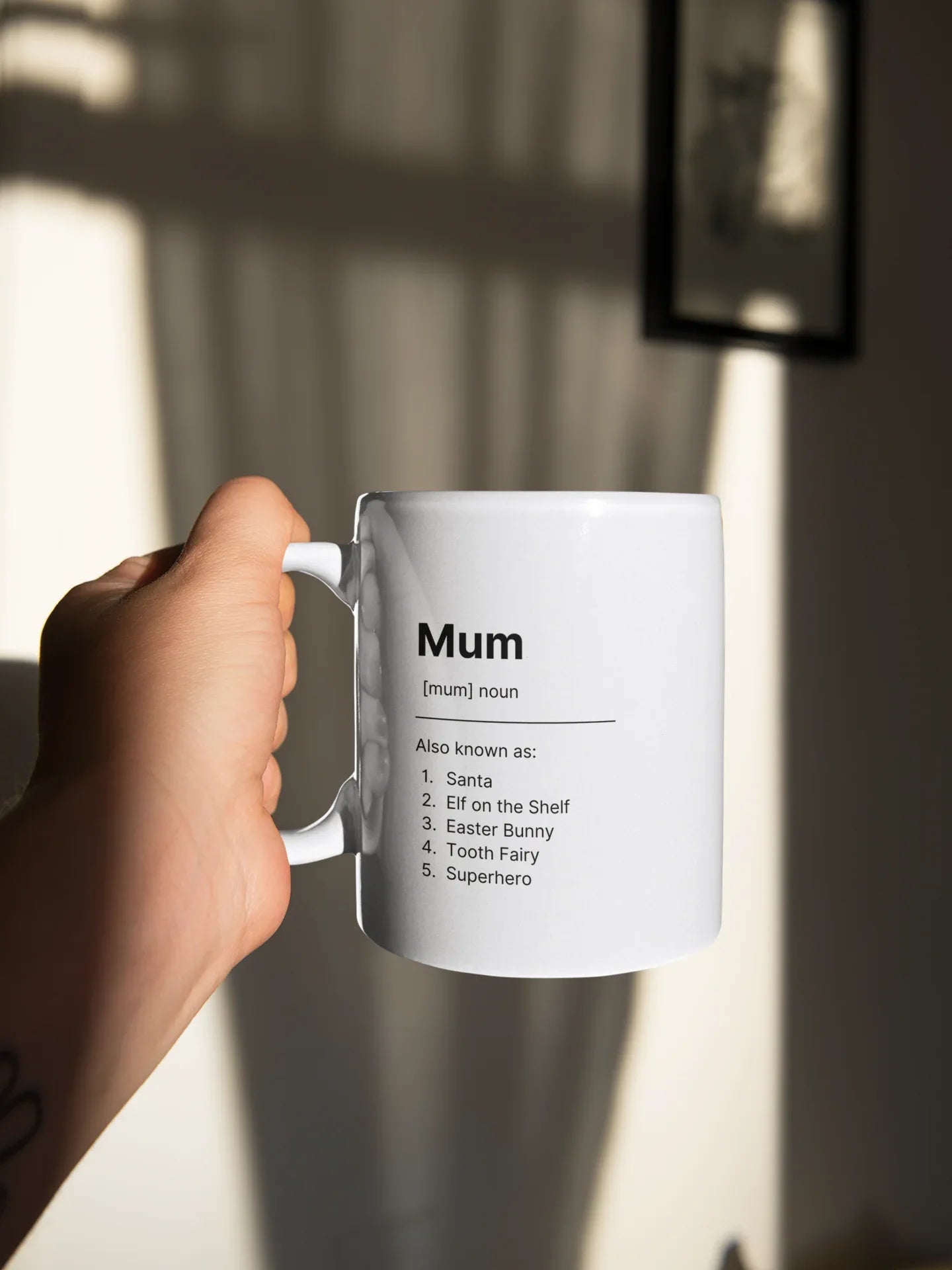White ceramic mug held by hand; shows “Mum” and short saying list