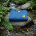 Royal blue sweatshirt with peace sign hand embroidery, resting on a rock