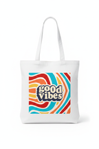 White canvas tote bag with centered 'good vibes' logo graphic and long handles