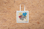 Beige canvas tote bag with blue and yellow graphic heart and text