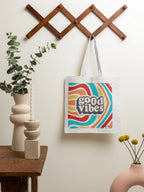 White tote bag with “good vibes” logo, long fabric handles