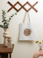 White canvas tote bag with brown woven handle and Sarah's Tote logo