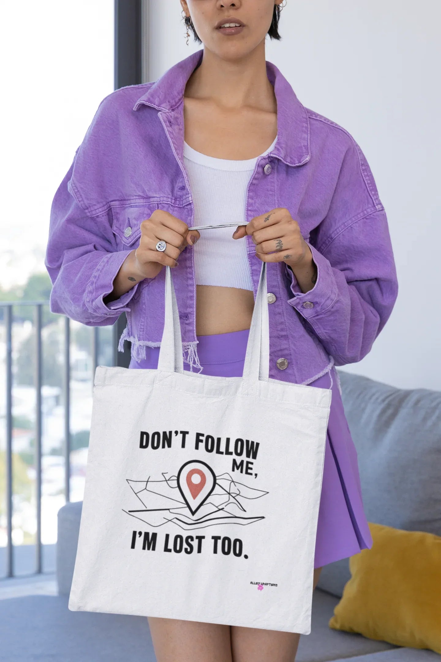 White canvas tote bag showing black "DON'T FOLLOW ME" and "I'M LOST TOO" text