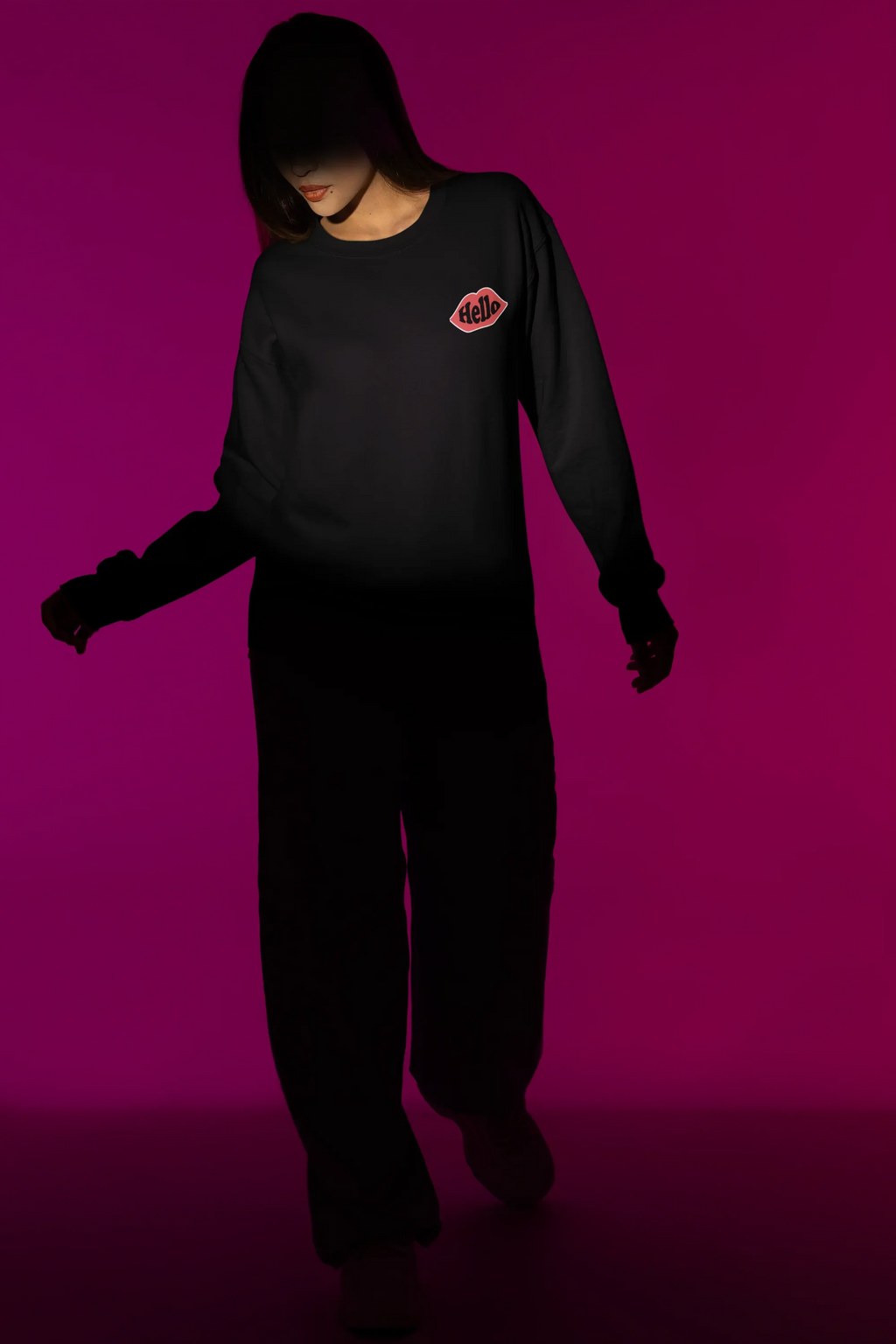 Black crewneck sweatshirt with embroidered lip logo patch on left chest.