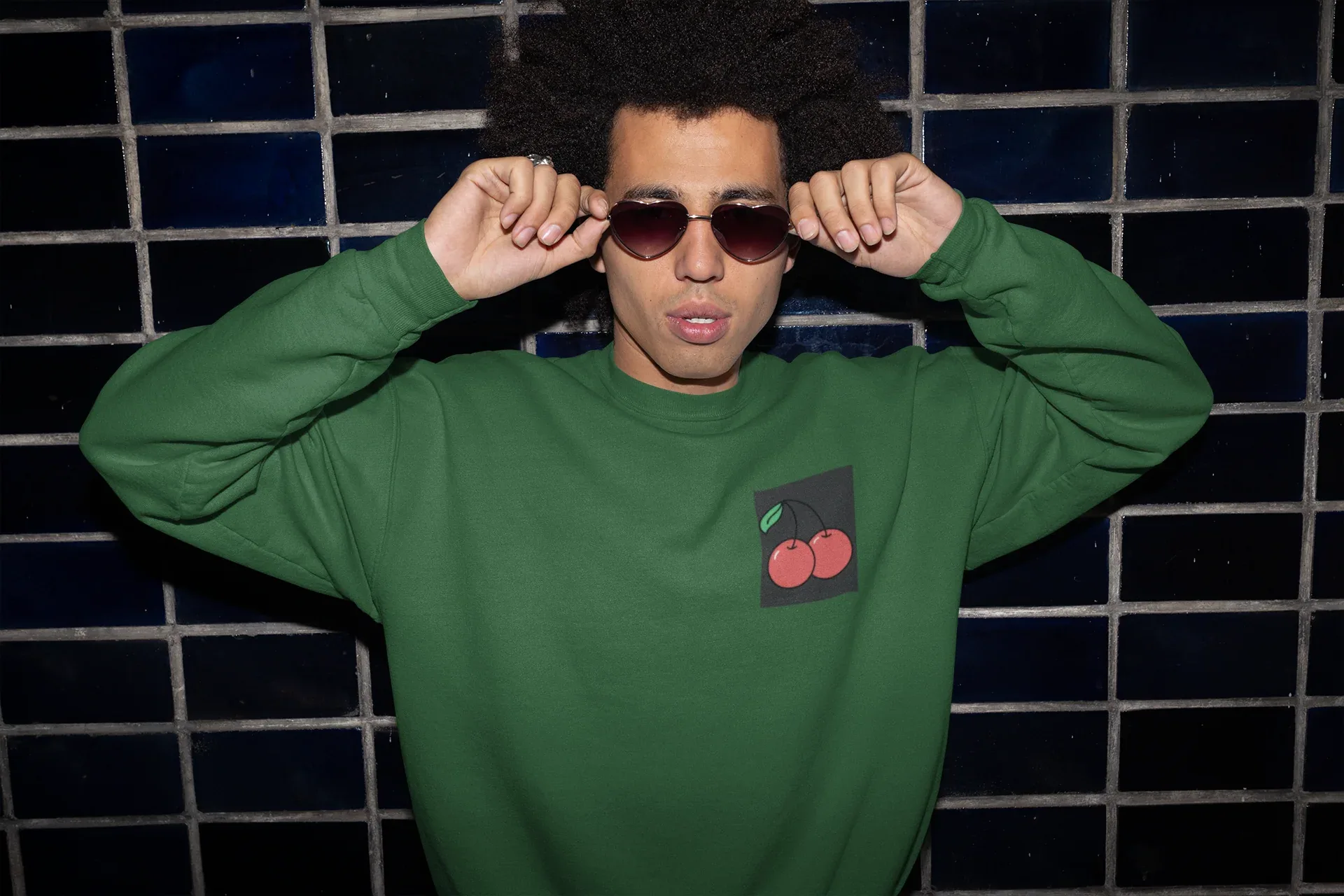 Embroidered sweatshirt in dark green with cherry logo patch at center chest