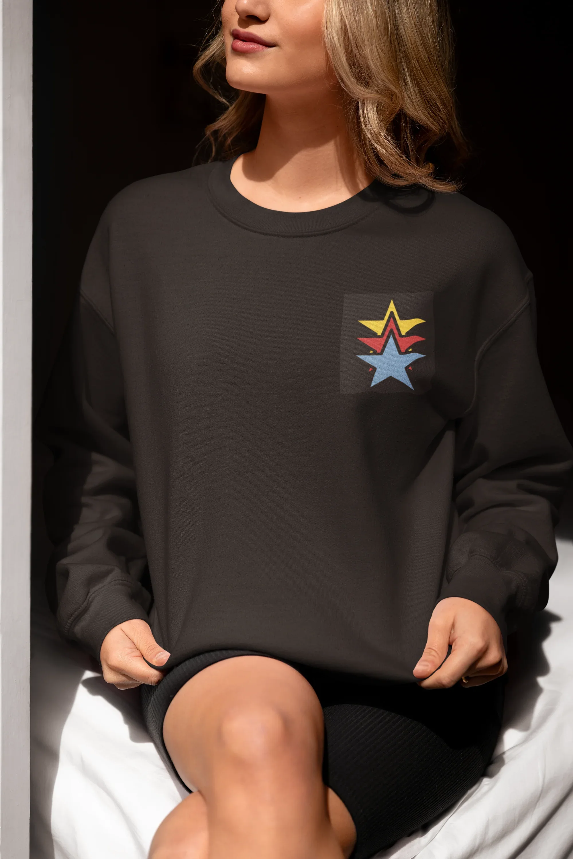 Black unisex sweatshirt with colorful star embroidery on chest, long sleeves