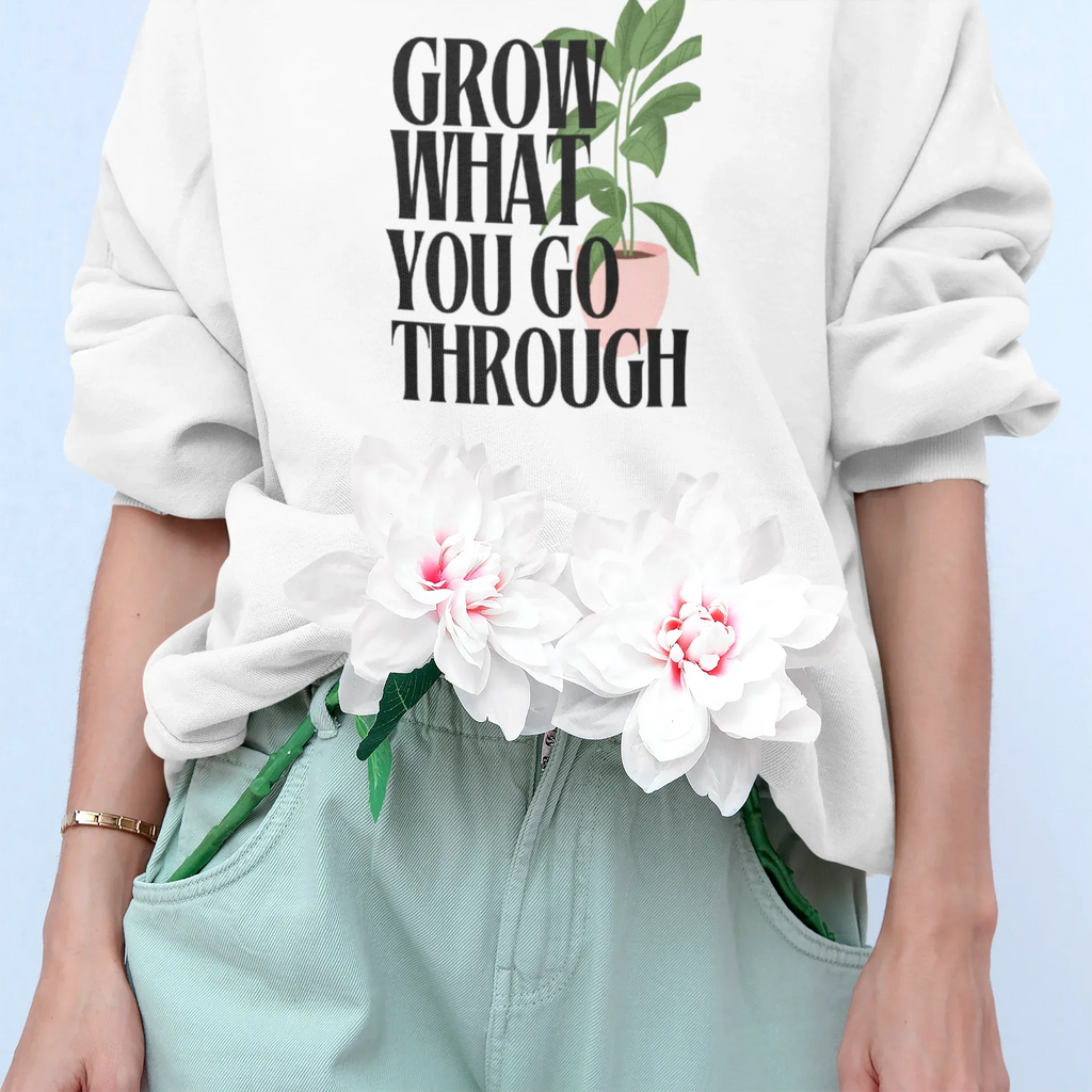 White sweatshirt with “Grow What You Go Through” text and leaf graphic