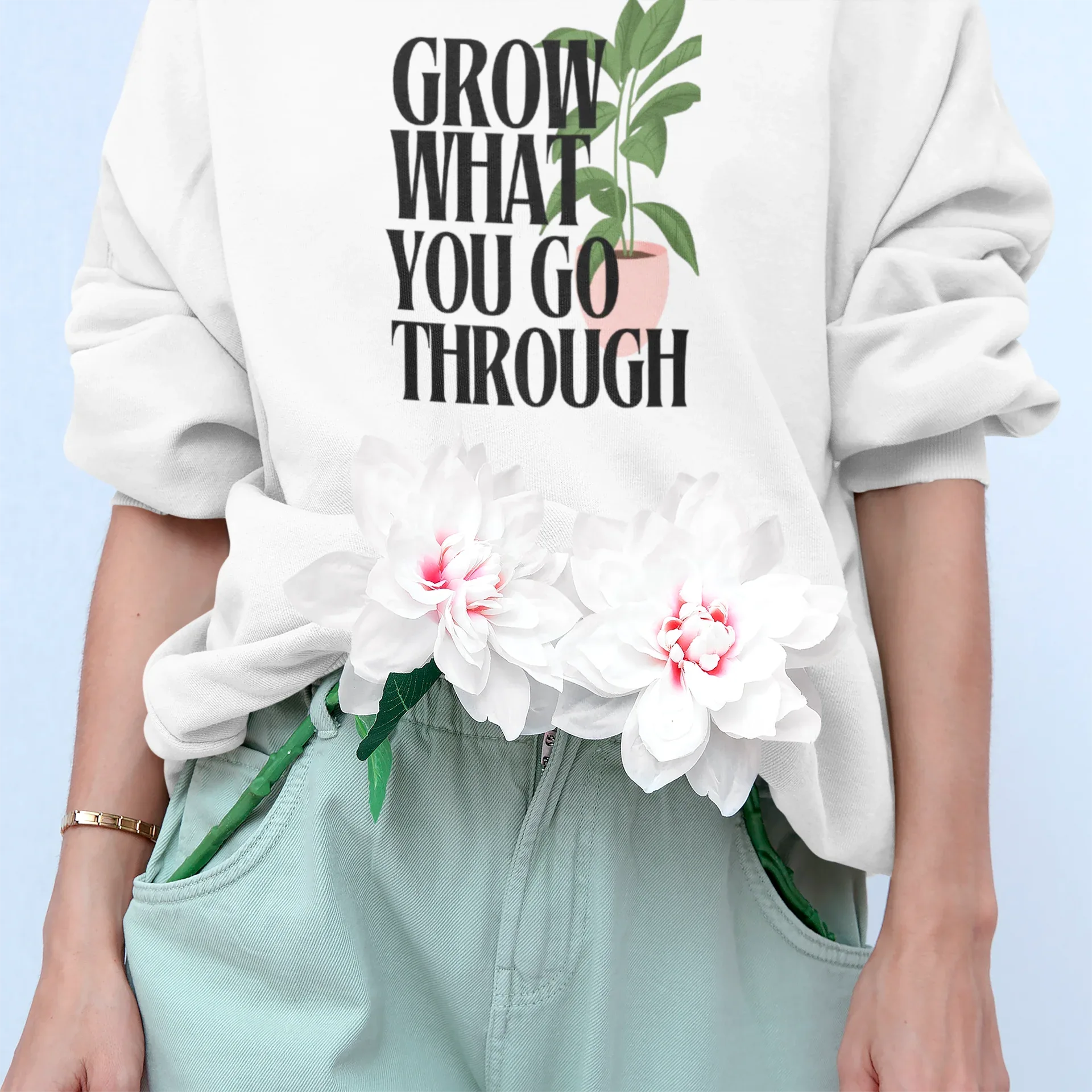 White sweatshirt with “Grow What You Go Through” text and leaf graphic