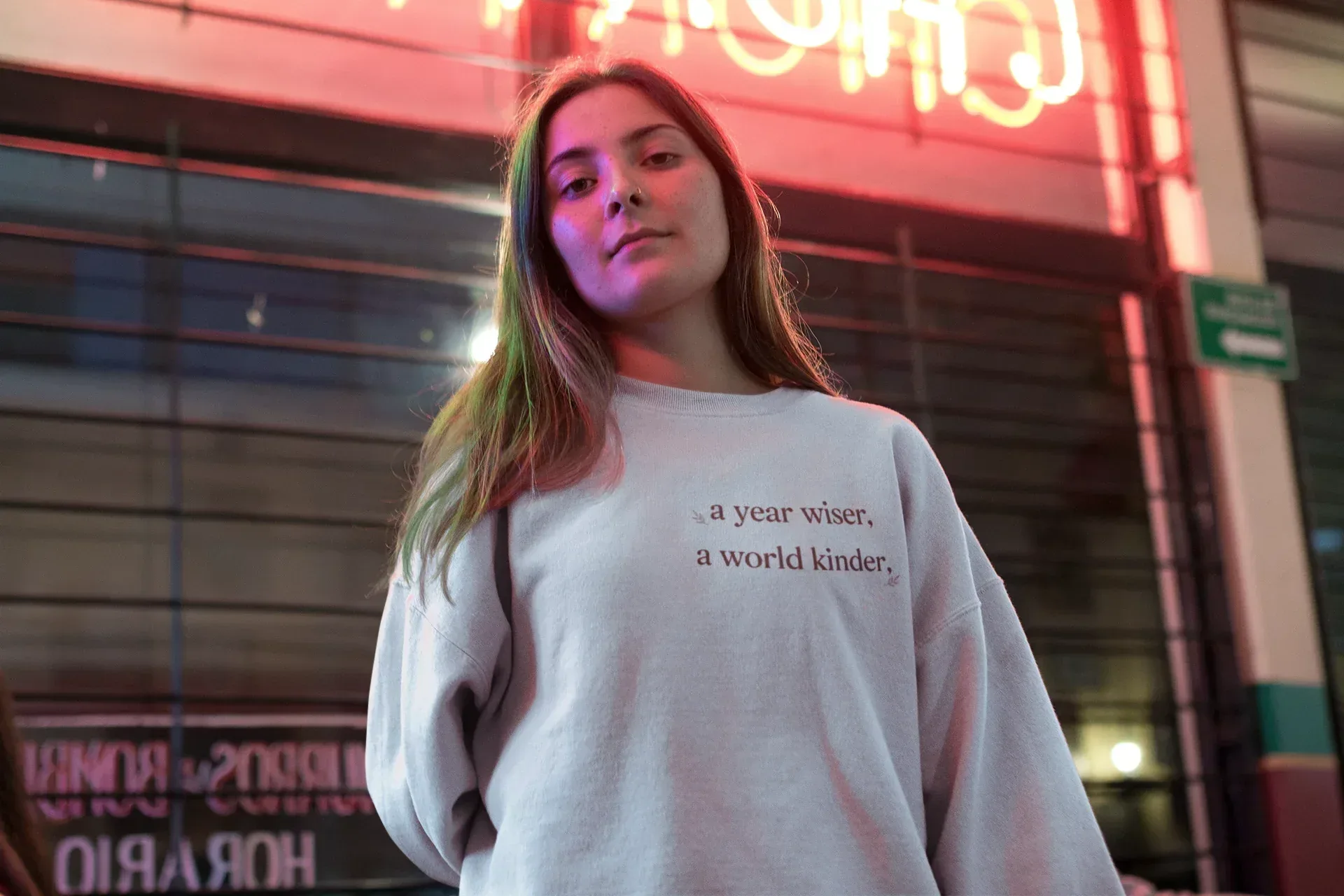 Light gray crewneck sweatshirt with a year wiser, a world kinder text