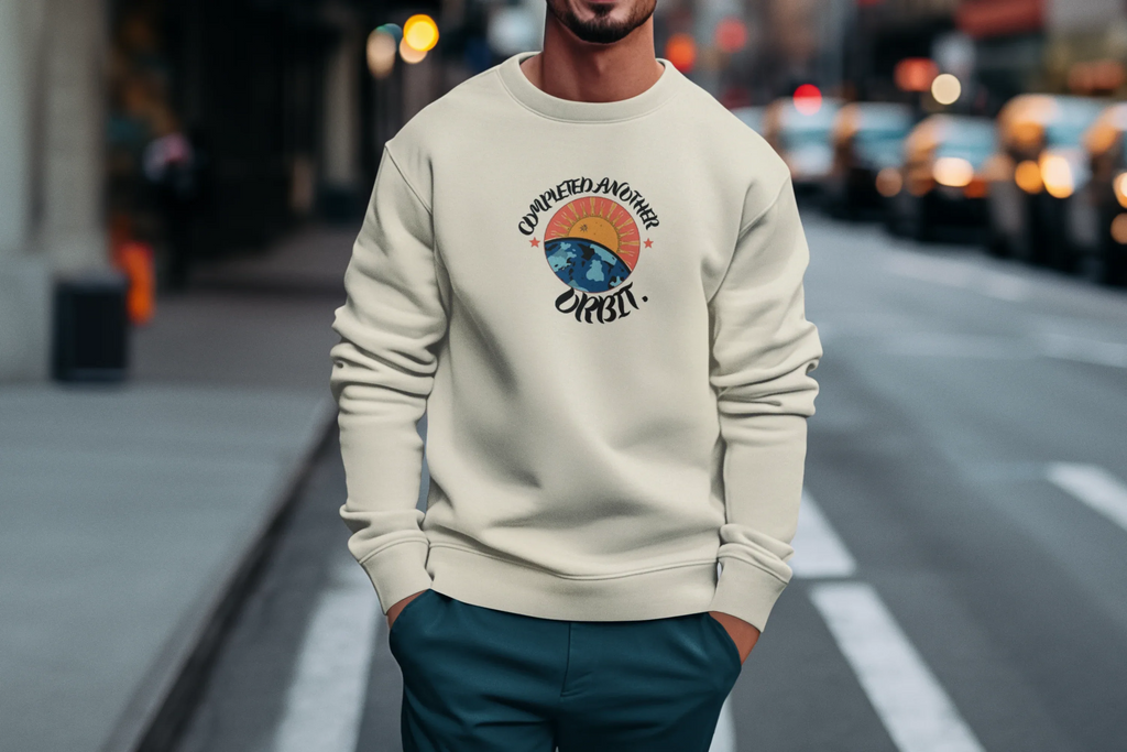 Oatmeal crewneck sweatshirt with circular planet graphic centered on the chest