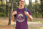 Purple T-shirt with mountain sunrise “RISE ABOVE” graphic, worn outdoors