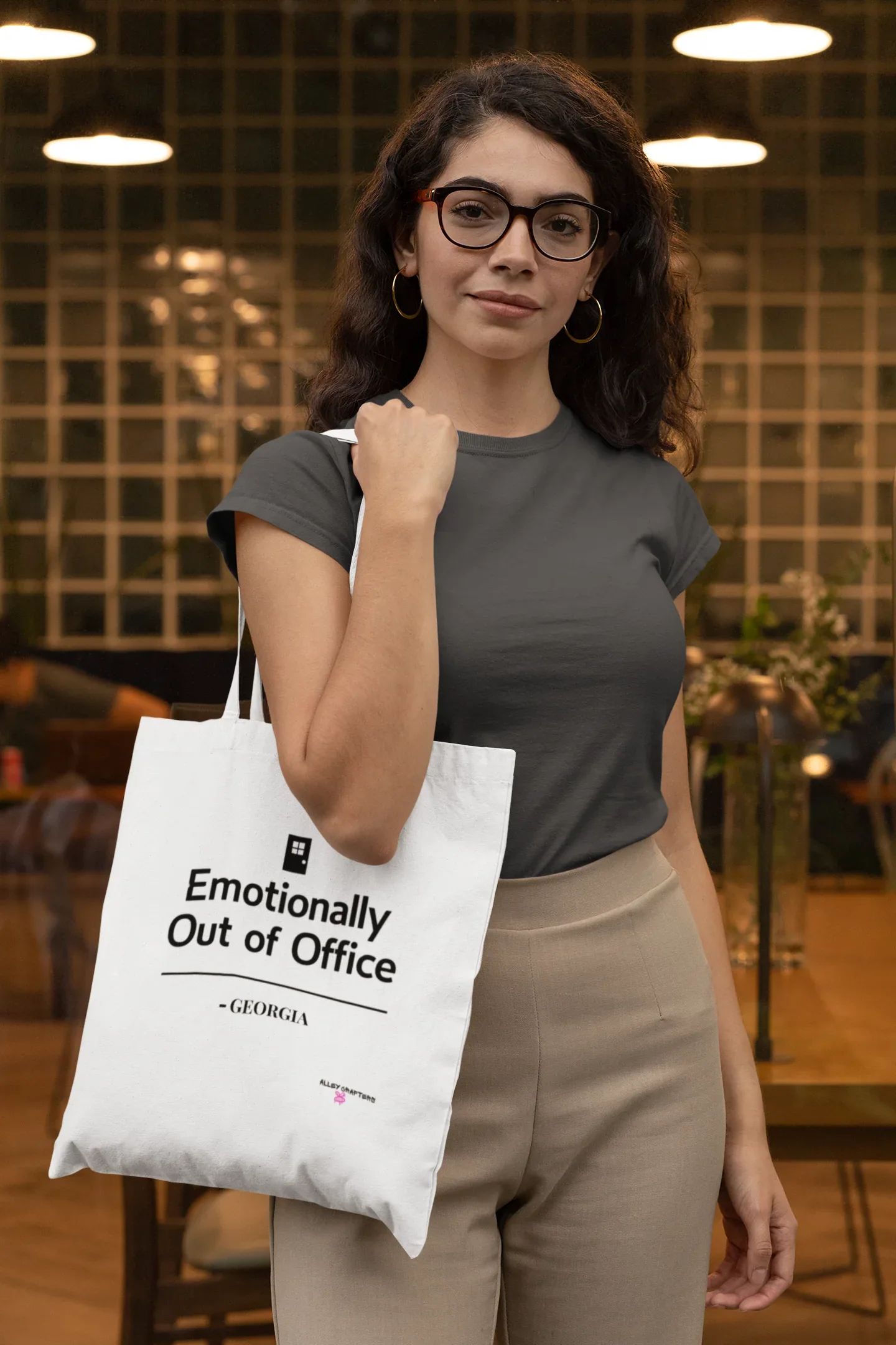 White tote bag with black top handles and printed slogan on the front panel