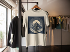 White short-sleeve T-shirt with mountain sunrise “RISE ABOVE” graphic on hanger