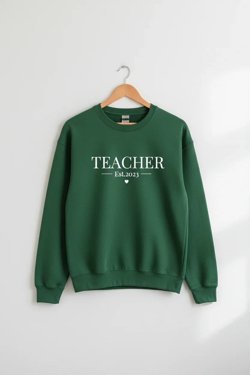 Green sweatshirt with TEACHER text and small Est.2023 graphic, crew neck
