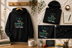 Black hoodie with drawstring hood, front pocket, and large colorful chest slogan text.