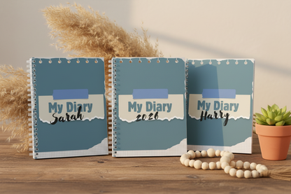 Three diaries standing upright with pampas grass