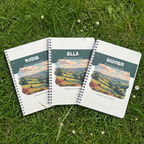 Three personalised countryside notebooks together on garden grass