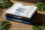 Folded Tropic Like It's Hot T-shirts stack in white, navy, and black with blue palm graphics