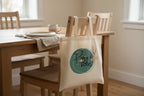 Cream canvas tote bag with round 'Tote.' logo print on dining chair
