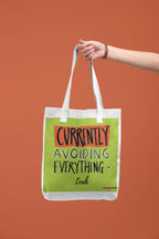 White canvas tote with lime green front panel and 'Currently Avoiding Everything-' text, Leah