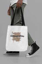 White canvas tote bag with 'Have a great day' print, held by handles