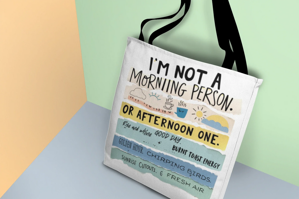Beige tote bag with 'I'm not a morning person' and 'or afternoon one' text print