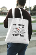 White canvas tote bag with black "DON'T FOLLOW ME" and "I'M LOST TOO" map-pin