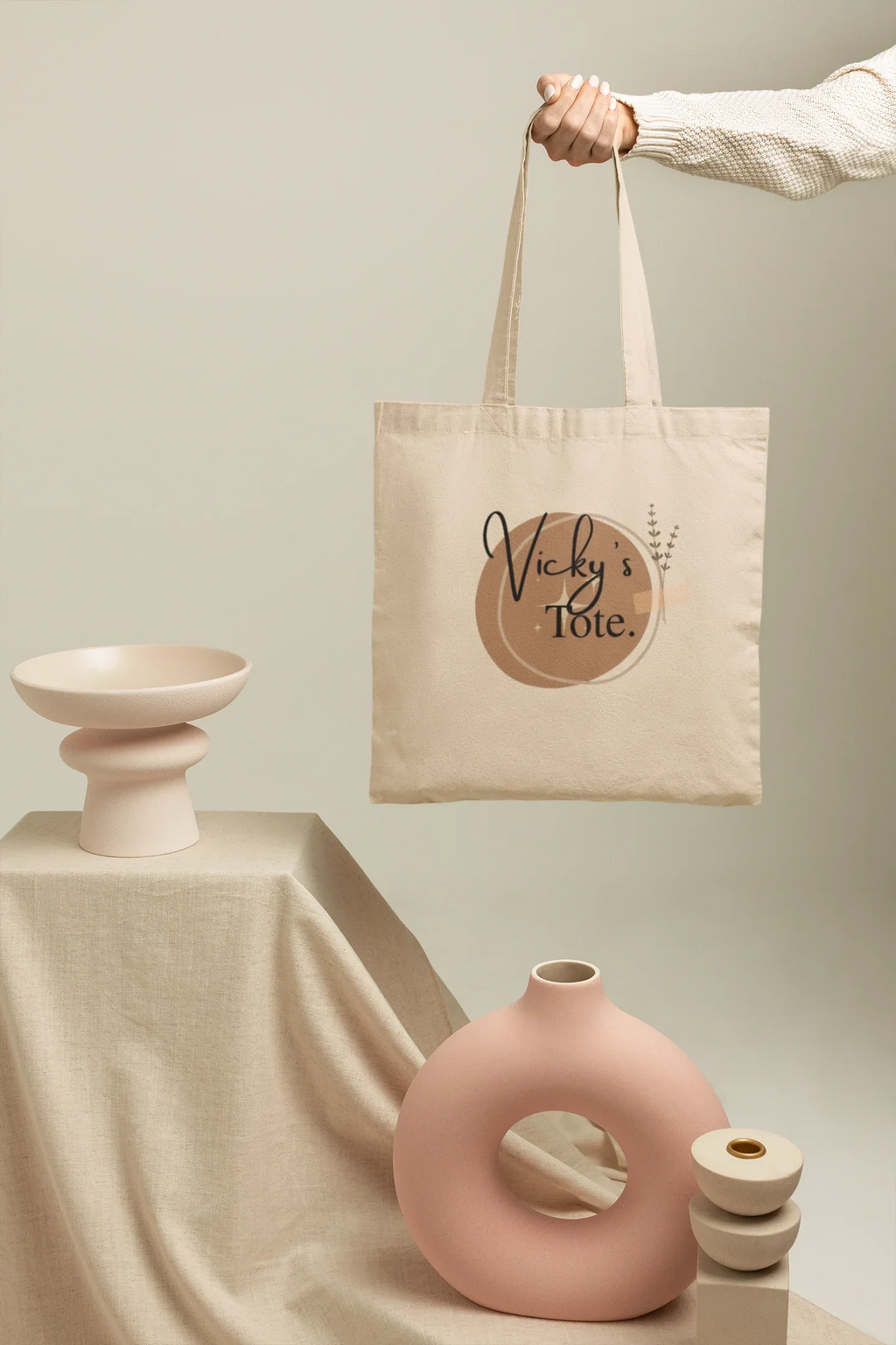 Light canvas tote bag held by rope handles with Vicky's Tote round logo