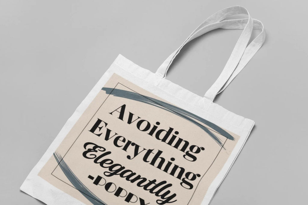 White tote bag with long handles, "Avoiding Everything Elegantly" front text