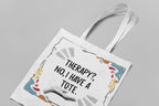 White tote bag with printed quote and colorful border, shown from above with handles.