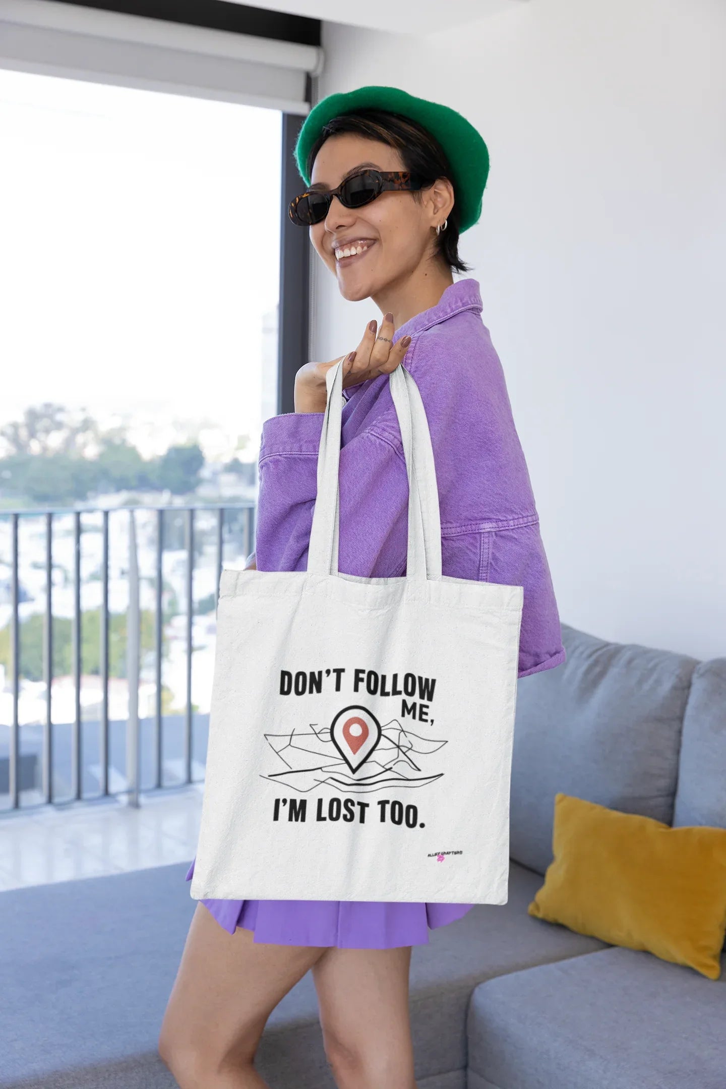 White canvas tote bag with black "DON'T FOLLOW ME" text and red location-pin graphic