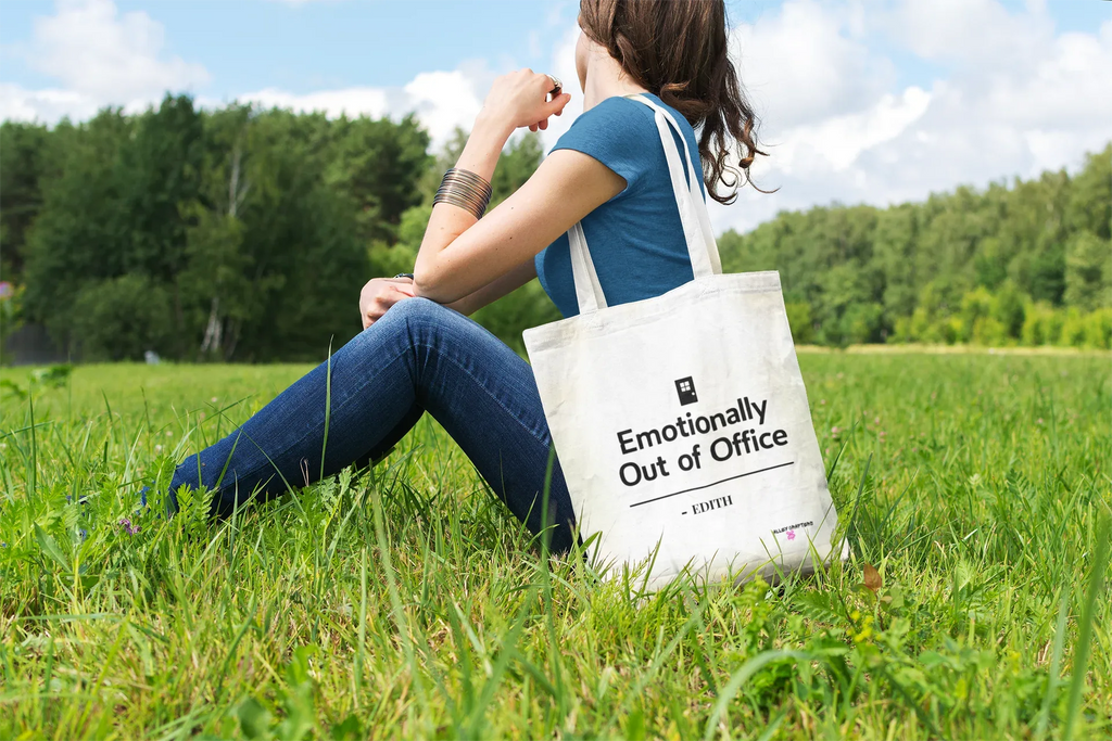 White tote bag with top handles and printed slogan, carried while seated outdoors