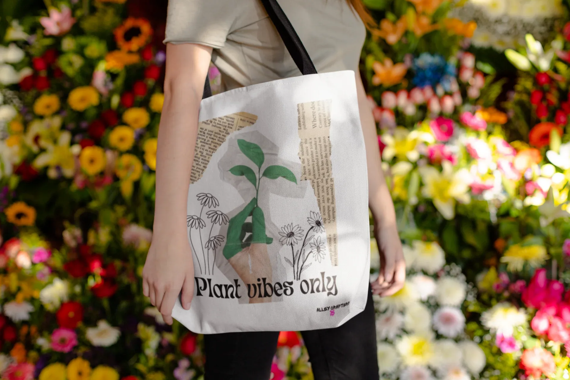 White tote bag with green plant graphic and 'Plant vibes only' print, worn by person