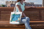 White canvas tote bag with tropical leaf graphic and teal “bad decisions” text.