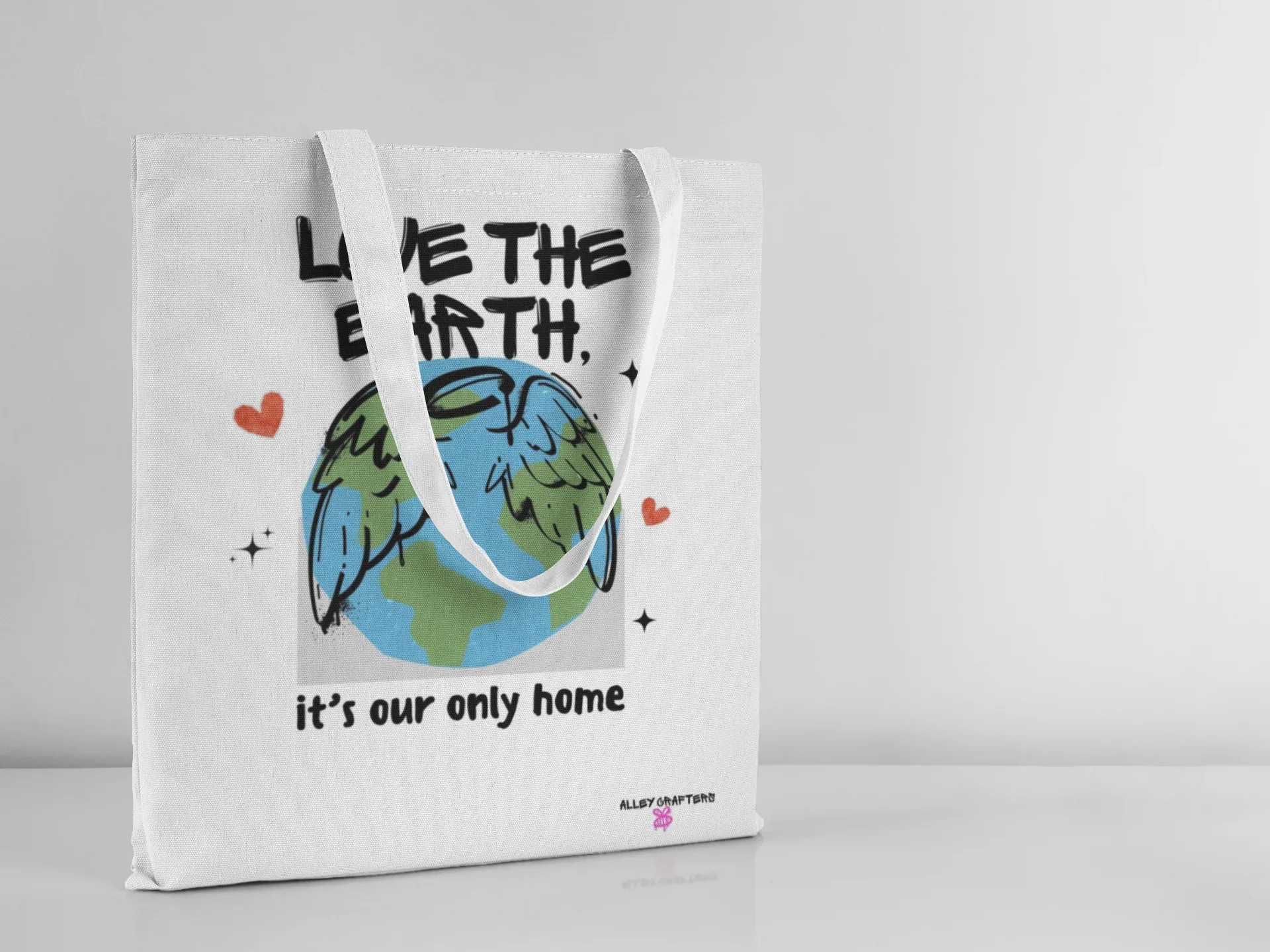 White tote bag with “Love the Earth” text, globe print, and loop handles