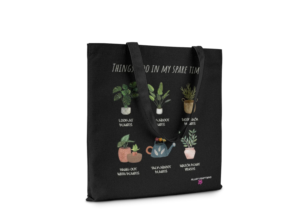 Black tote bag with plant-themed print and handles, text across top