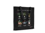 Black tote bag with plant-themed print and handles, text across top