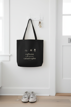 Black tote bag hanging with coffee graphic and two handle straps